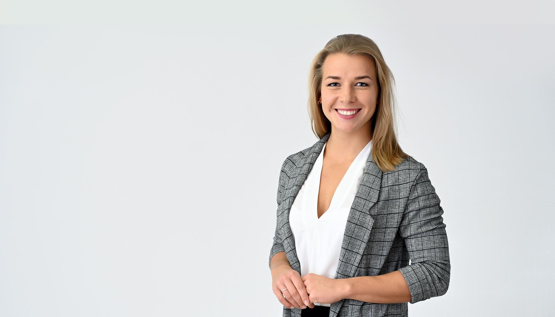 A smiling professional woman in a grey checked blazer